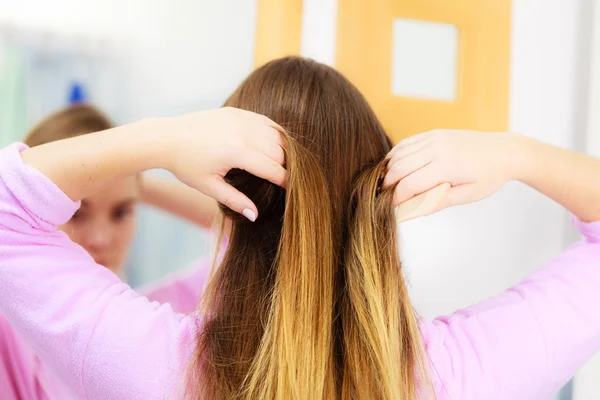 Frau kämmt ihre langen Haare im Badezimmer — Stockfoto