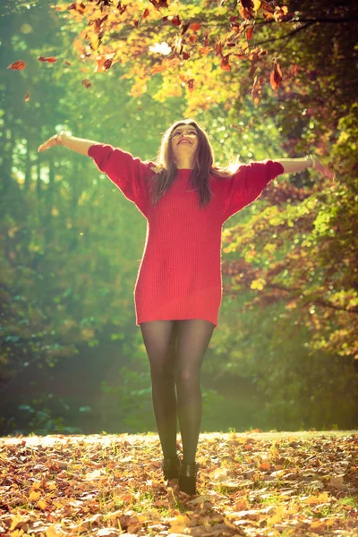 Mädchen wirft Blätter um sich. — Stockfoto