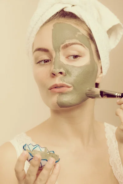 Femme appliquant avec un masque de boue d'argile brosse sur son visage — Photo