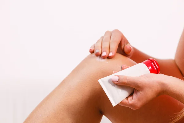 Mujer poniendo ungüento en lesión cuidado de la piel de rodilla —  Fotos de Stock