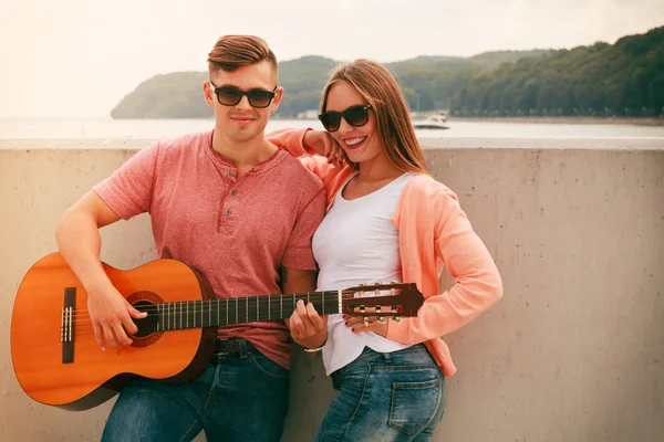 Gelukkige paar met gitaar buiten — Stockfoto