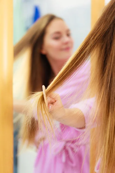 Frau kämmt ihre langen Haare im Badezimmer — Stockfoto