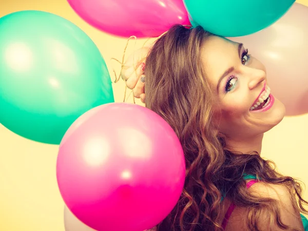 Žena drží spoustu barevných balónků — Stock fotografie