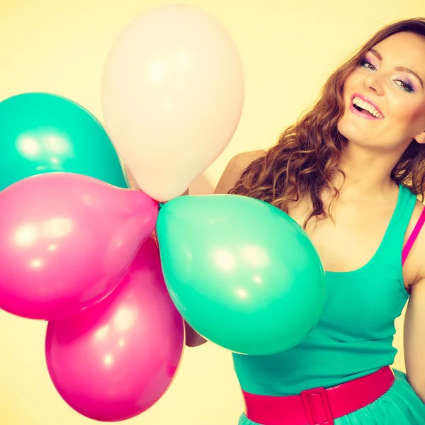 Женщина держит кучу разноцветных воздушных шаров — стоковое фото