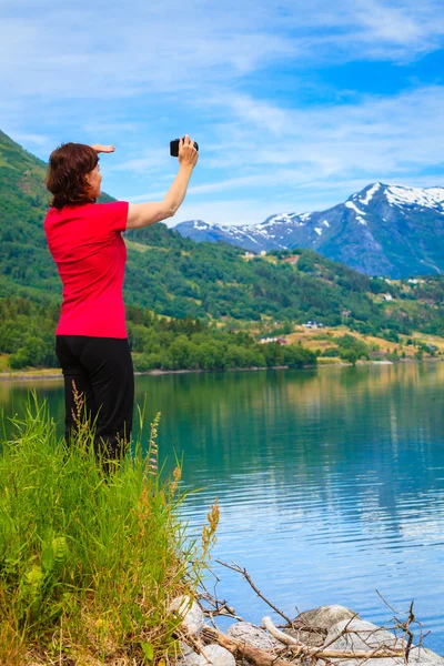 Turista tomando fotos en noruego fiordo —  Fotos de Stock