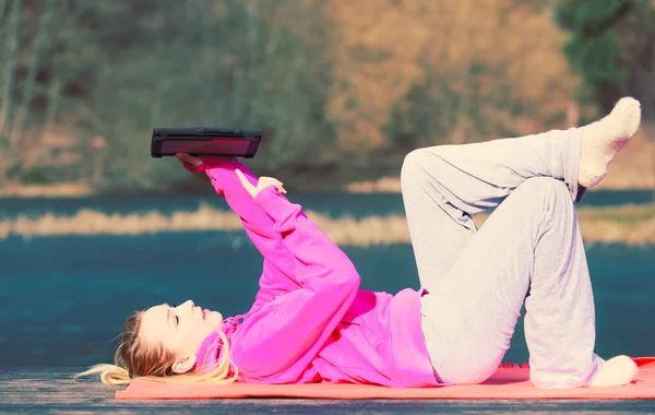 Meisje liggend in park met behulp van Tablet PC. — Stockfoto