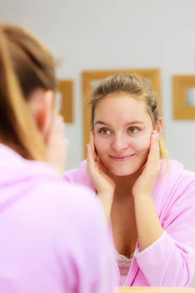 Frau reinigt ihr Gesicht mit Peeling im Badezimmer. — Stockfoto