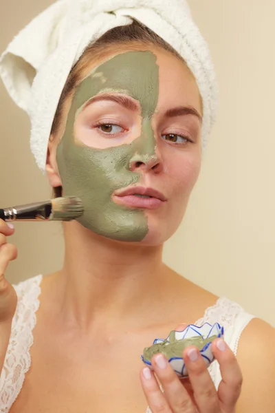 Femme appliquant avec un masque de boue d'argile brosse sur son visage — Photo