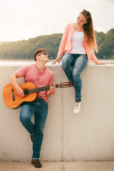 Счастливая пара с гитарой на улице — стоковое фото