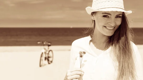 Chica sonriente con flor en la playa — Foto de Stock