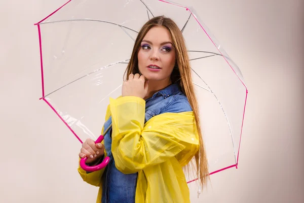 Frau im wasserdichten Mantel mit Regenschirm — Stockfoto