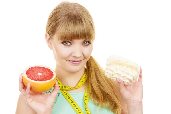 Женщина выбирая фрукты или торт сделать диетический выбор — стоковое фото