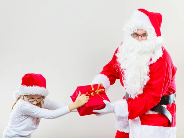 Weihnachtsmann givig Geschenk für Mädchen. — Stockfoto