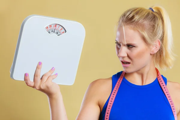 Сердитая женщина с весами, время потери веса для похудения — стоковое фото
