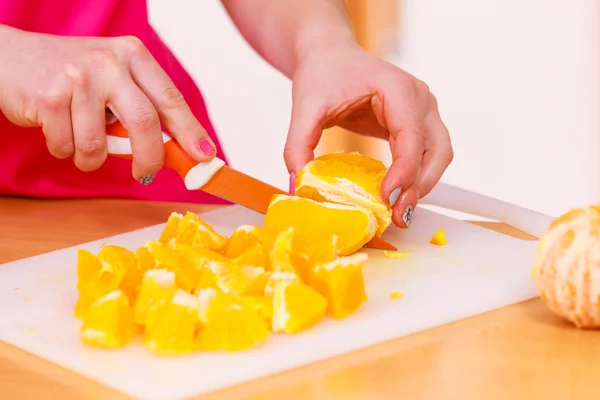 Kadın ev kadını mutfakta turuncu meyve kesme — Stok fotoğraf