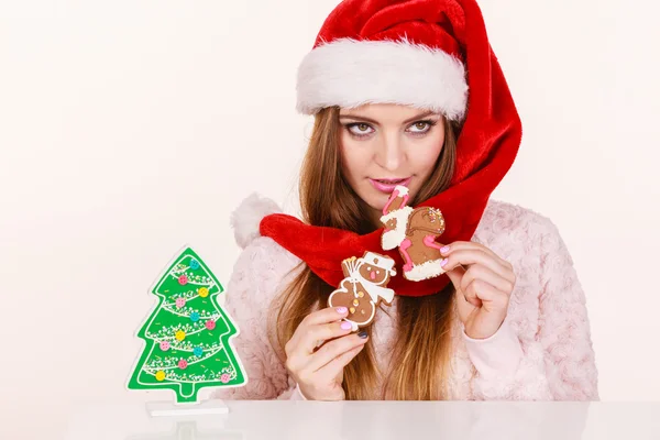 Woman santa claus hat with gingerbread cookies. Christmas — Stock Photo, Image