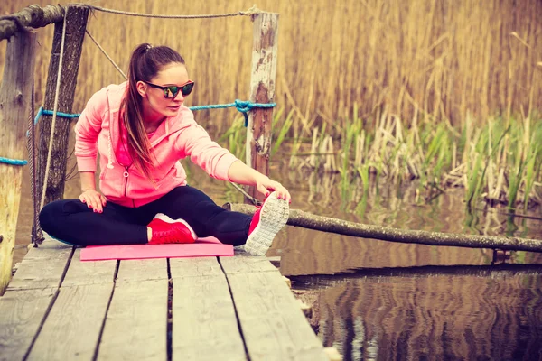 Girl training in sporty clothes on lake shore — Stock Photo, Image