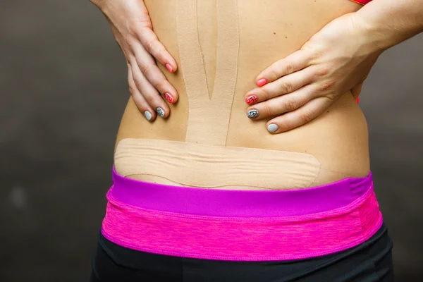 Mujer con kinesio médico grabando en la espalda — Foto de Stock