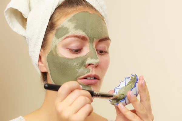 Femme appliquant avec un masque de boue d'argile brosse sur son visage — Photo