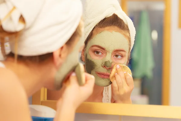 Γυναίκα βγάζει λάσπη μάσκα προσώπου αργίλου στο μπάνιο — Φωτογραφία Αρχείου