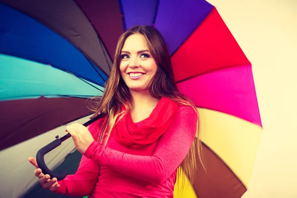 Woman standing under multicolored umbrella — Stock Photo, Image