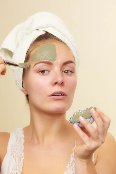 Femme appliquant avec un masque de boue d'argile brosse sur son visage — Photo