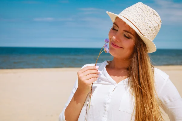 Menina sorridente com flor na praia — Fotografia de Stock