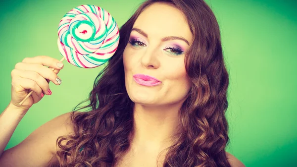 Smiling girl with lollipop candy on green — Stock Photo, Image
