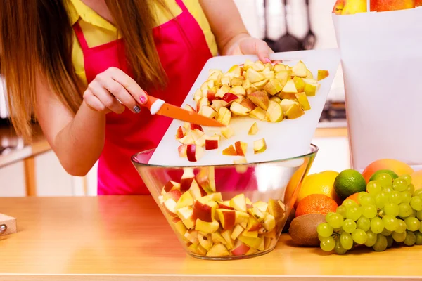 Mujer ama de casa en cocina cortando frutas de manzana — Foto de Stock