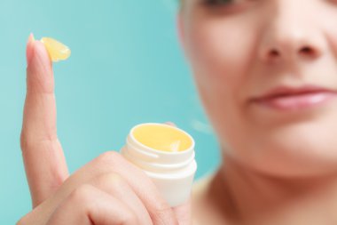 woman applying balsam for lips clipart