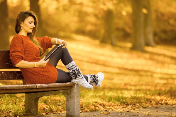 Žena na lavičce v parku s tabletem. — Stock fotografie