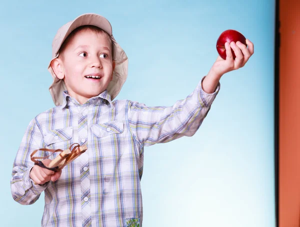 Junge benutzt Schleuderschuss, um Apfel zu halten. — Stockfoto