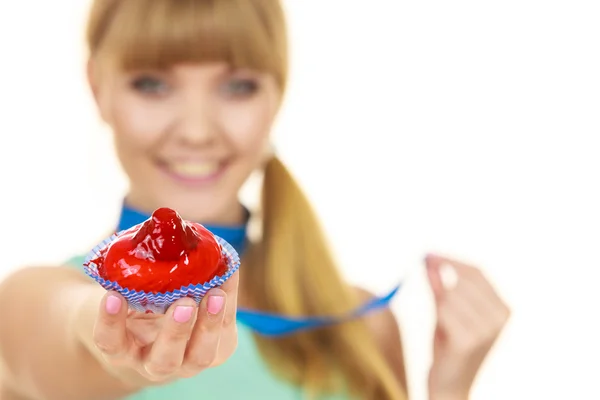 Frau hält Cupcake mit Maßband am Hals — Stockfoto