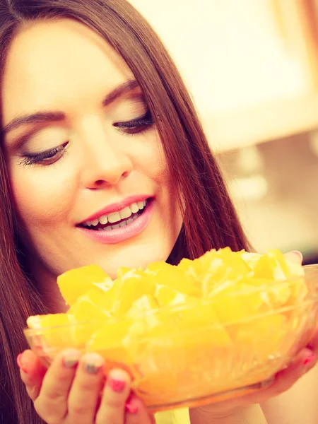 Mujer sostiene cuenco lleno de frutas de naranja en rodajas — Foto de Stock