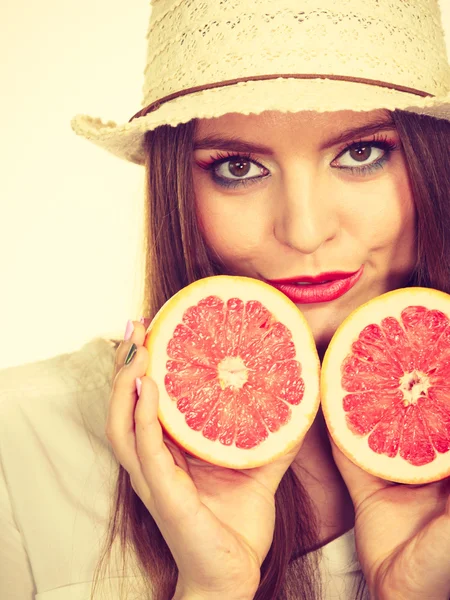 Vrouw houdt twee helften pompelmoes citrusvruchten in handen — Stockfoto
