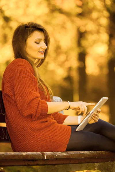 Жінка на лавці в парку з планшетом . — стокове фото