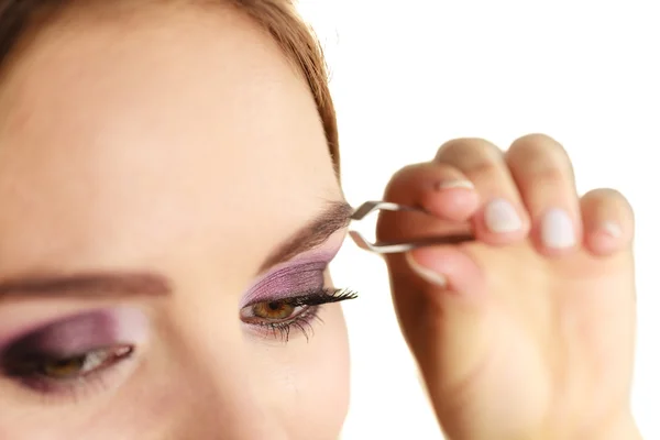 Woman tweezing eyebrows plucking with tweezers — Stock Photo, Image