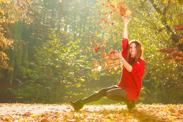 Игривая женщина на открытом воздухе играет с листьями . — стоковое фото
