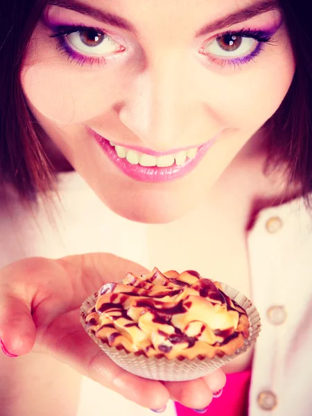 Uśmiechnięta kobieta trzyma tort w dłoni — Zdjęcie stockowe