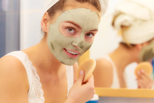 Femme enlever masque de boue d'argile faciale dans la salle de bain — Photo