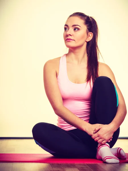 Gymnastiek meisje zit op matras. — Stockfoto