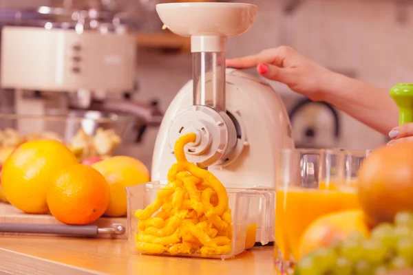 Mulher fazendo suco de laranja na máquina do juicer — Fotografia de Stock