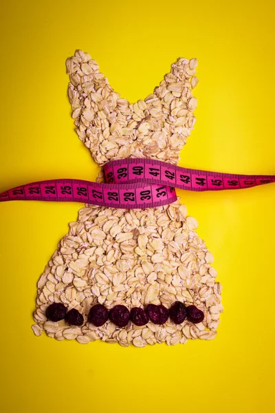 Dress shape made from oatmeal with measuring tape — Stock Photo, Image