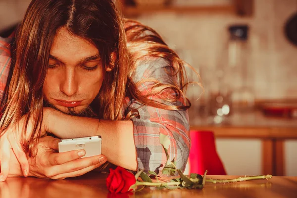 Homme inquiet avec rose et téléphone portable . — Photo