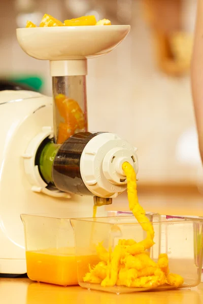 Het maken van jus d'orange in de juicer machine in keuken — Stockfoto