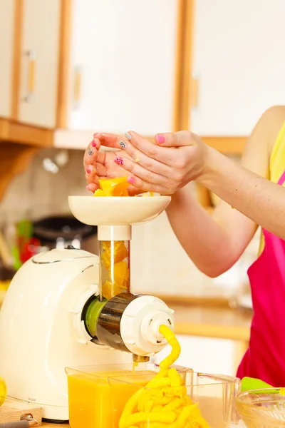 Frau macht Orangensaft in Saftpresse — Stockfoto