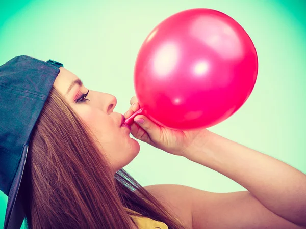 Mujer adolescente inflando globo rojo . — Foto de Stock