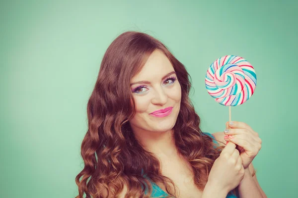 Smiling girl with lollipop candy on teal — Stock Photo, Image