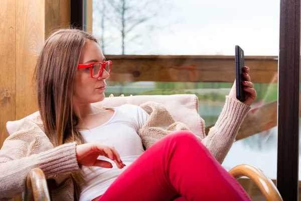 Woman sitting on chair using phone at home — Stock Photo, Image