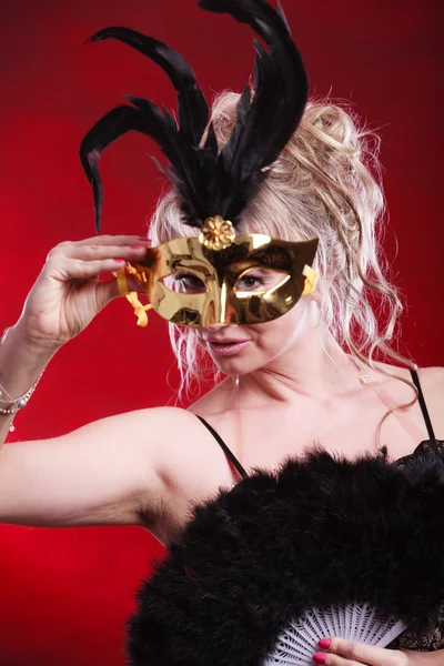 Женщина с веером из перьев карнавальной маски в руке — стоковое фото